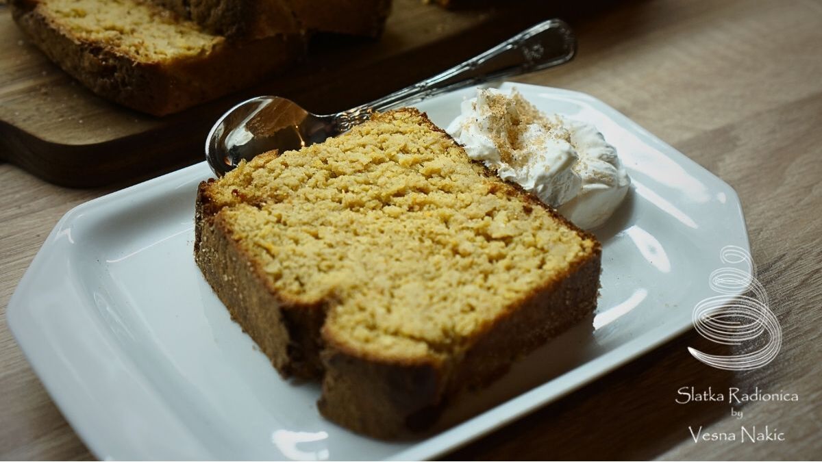 kolač od slanutka s tučenim slatkim vrhnjem na duguljastom bijelom tanjuru uz