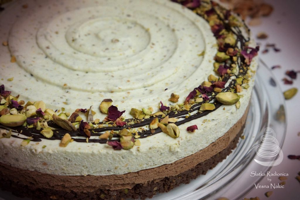 Torta od pistacija i čokolade, ukrašena tamnom čokoladom, komadićima pistacija i laticama suhih ruža