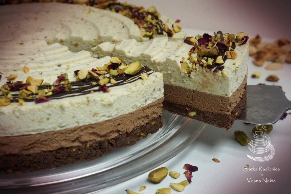 Torta od pistacija i čokolade, ukrašena tamnom čokoladom, komadićima pistacija i laticama suhih ruža