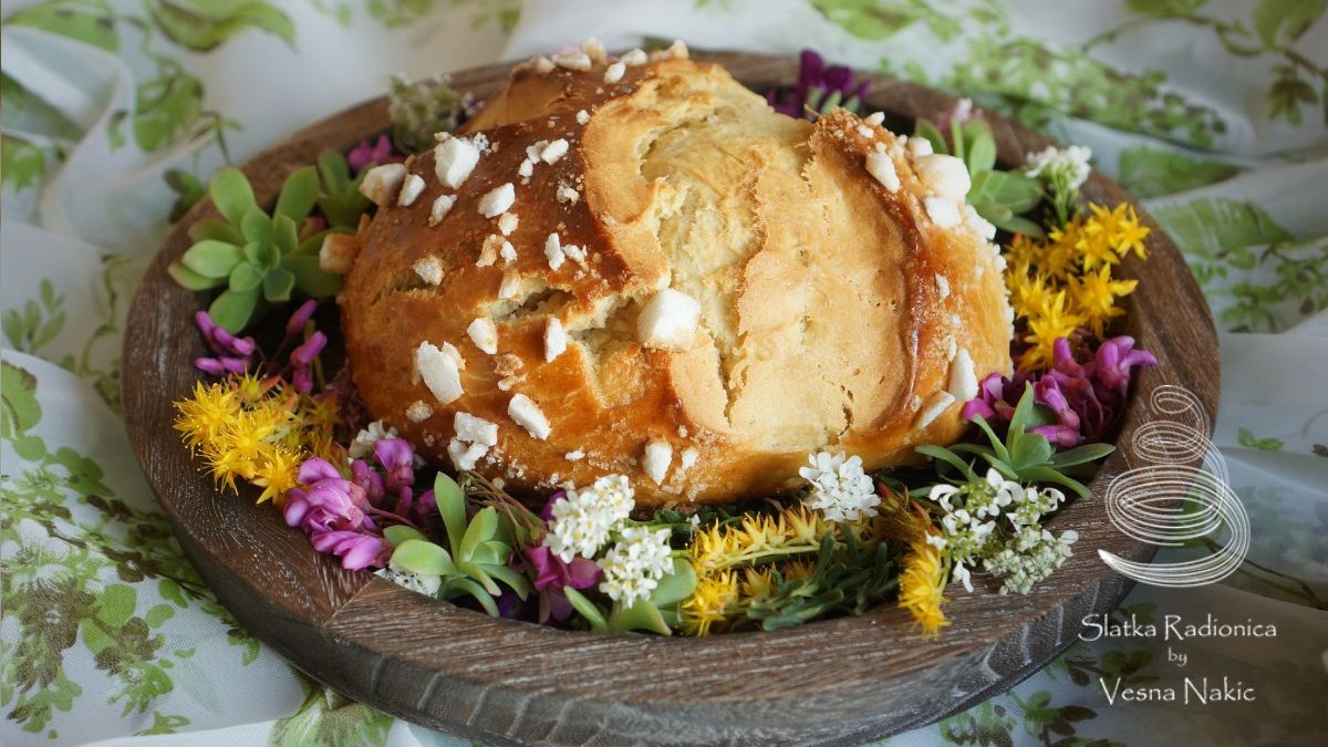 Pinca, pogača ili sirnica na drvenom poslužavniku ukrašena poljskim cvijećem