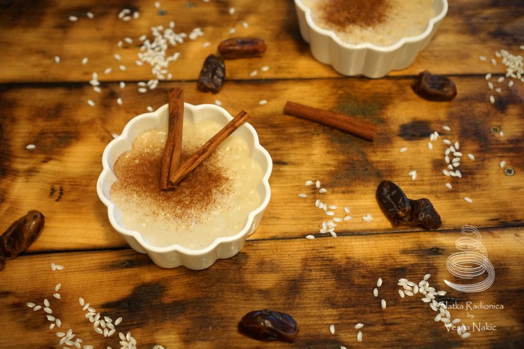 Sutlija ili riža na mlijeku u bijeloj keramičkoj zdjelici ukrašena korom cimeta na drvenom stolu