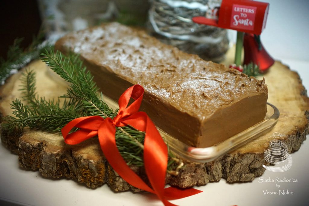 Mamina torta s datuljama servirana na drvenoj podlozi s blagdanskim detaljima u zeleno-crvenim bojama